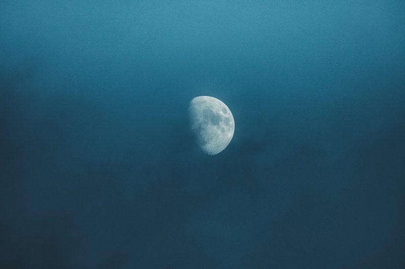 waxing moon shining in cloudy sky