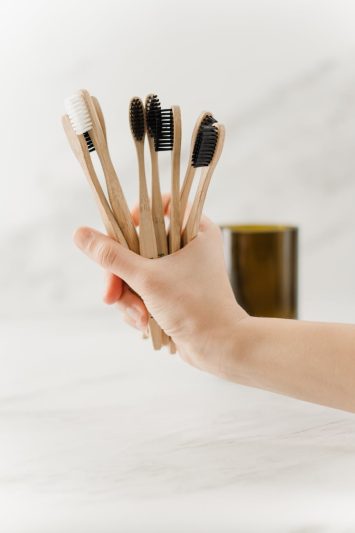 person holding brown wooden toothbrush