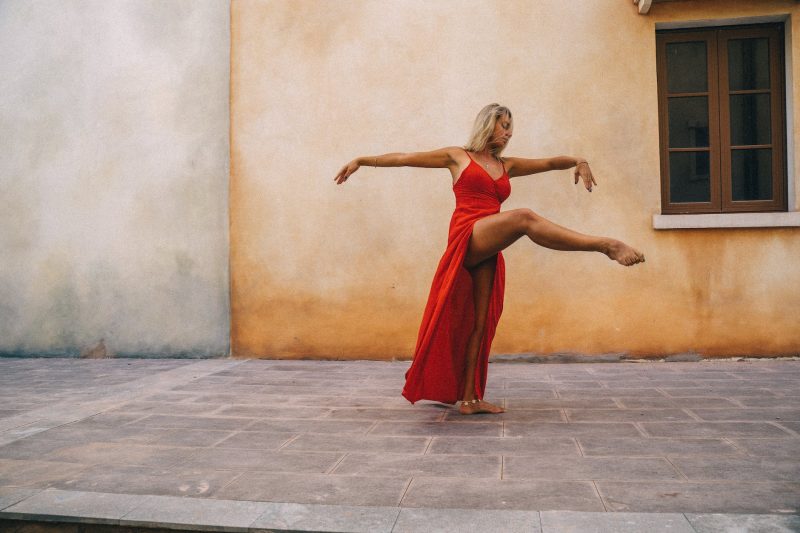 woman in red dress dancing on a courtyard