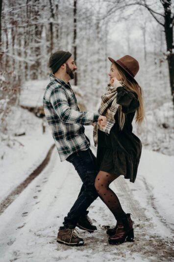 a couple dancing in the middle of a snow covered road