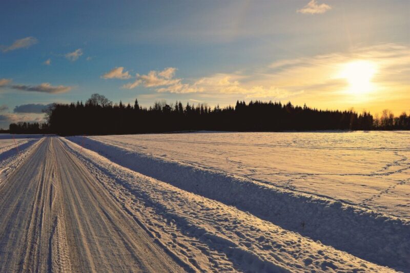 snow covered road during golden hour