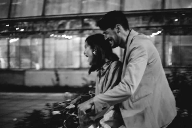 monochrome photo of a couple riding a bicycle