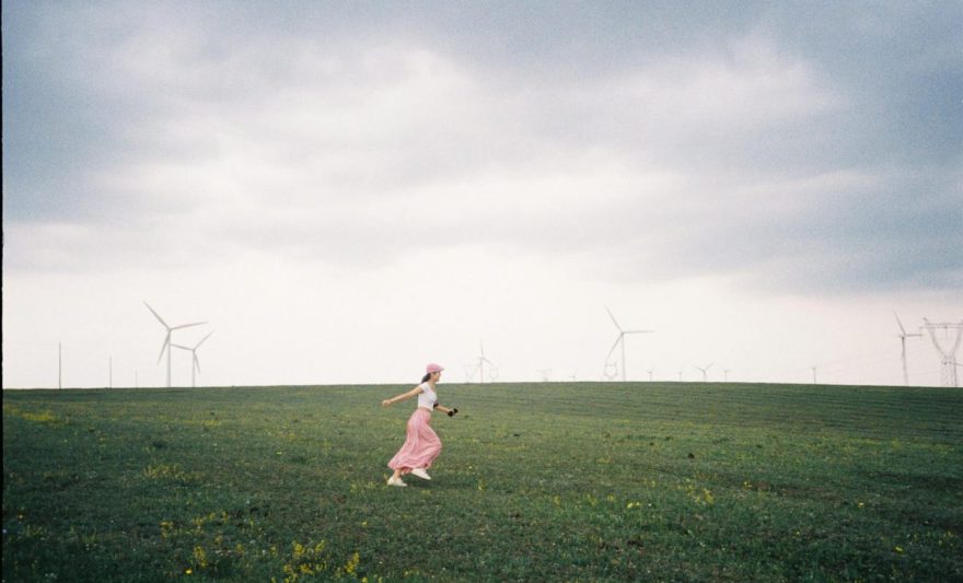 woman on a field among windmills