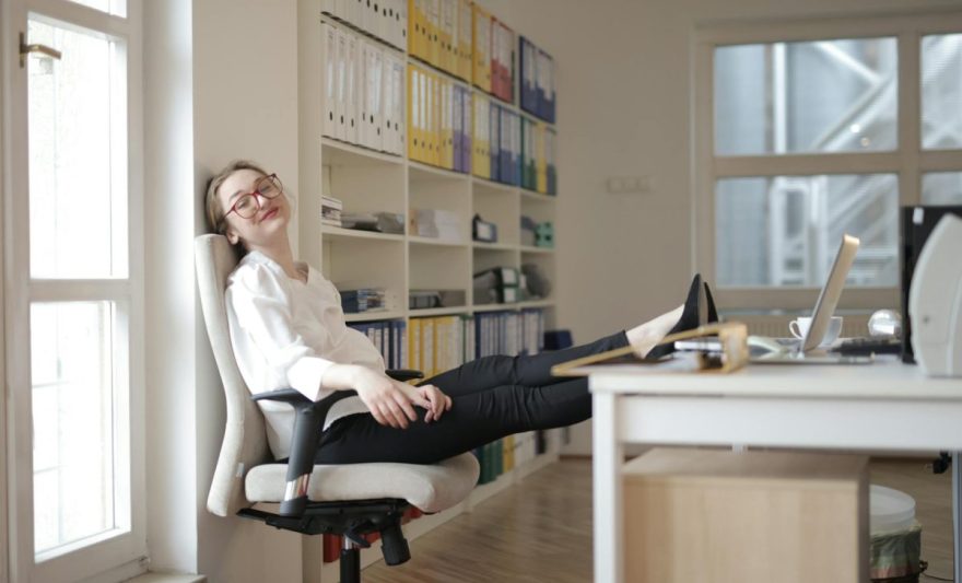 relaxed female secretary with feet on table in workplace