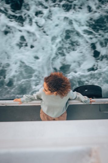 top view of a woman leaning overboard on a ship