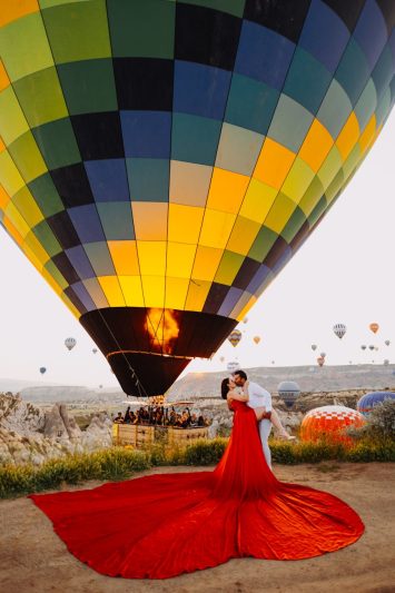 a couple kissing on the background of hot air balloons in cappadocia