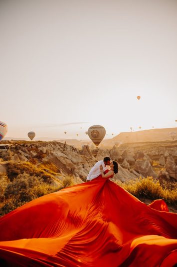 a couple kissing on the background of hot air balloons in cappadocia