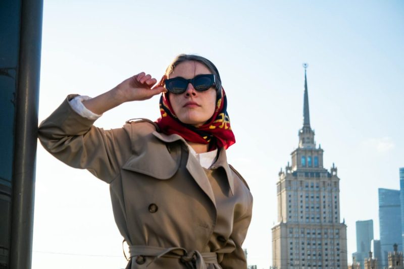 a woman in brown coat wearing black sunglasses