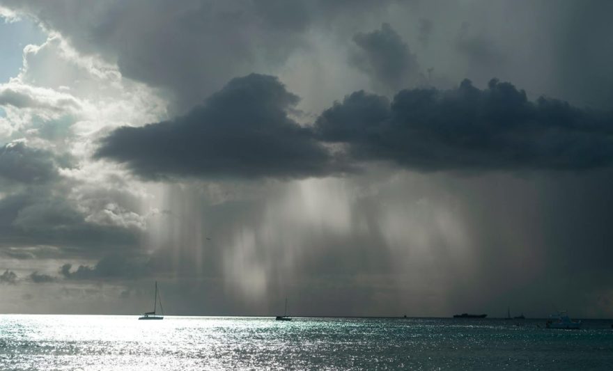 a boat is seen in the ocean under a dark cloud