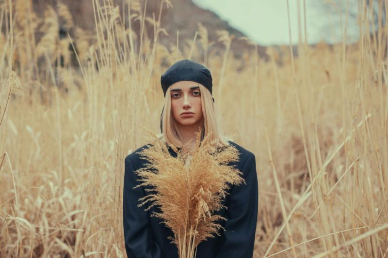 young woman in field of tall beige grasses