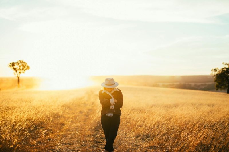 woman posing in autumn field on sunset