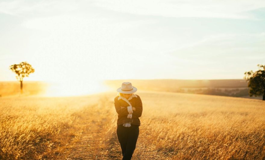 woman posing in autumn field on sunset