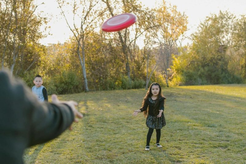 girl in black dress catching flying disc