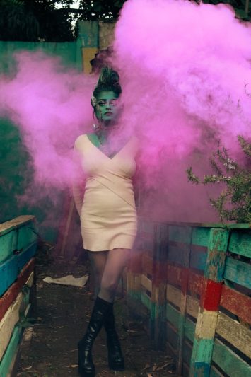 mystical woman with pink smoke in artistic setting