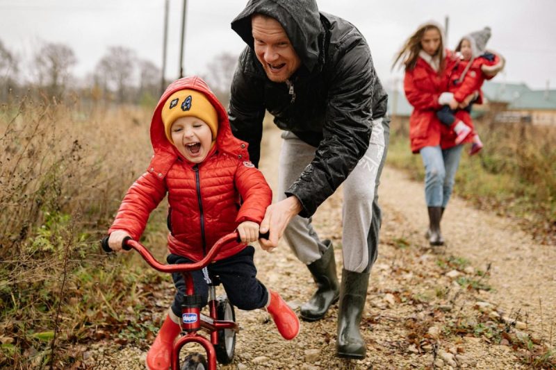 father teaching his son how to ride a bike