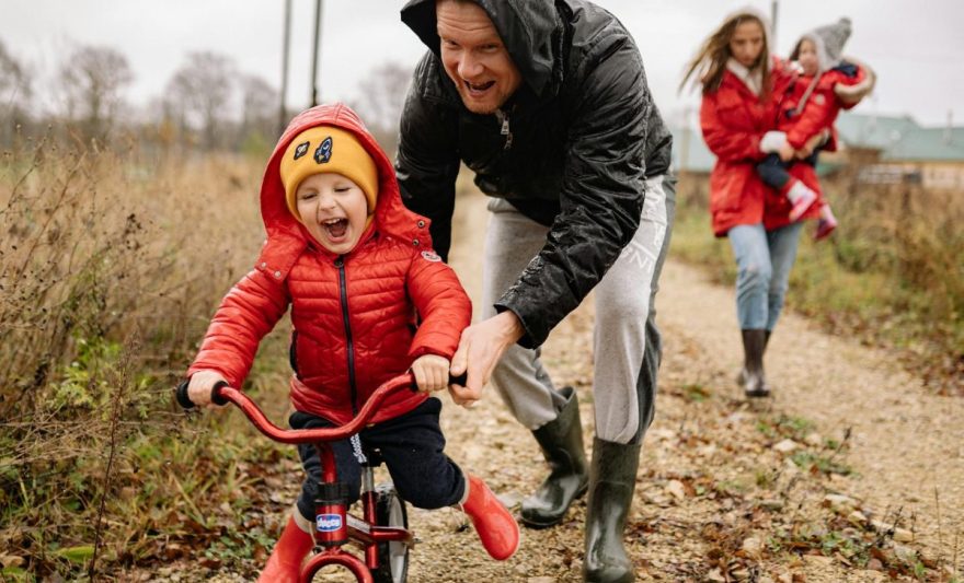 father teaching his son how to ride a bike