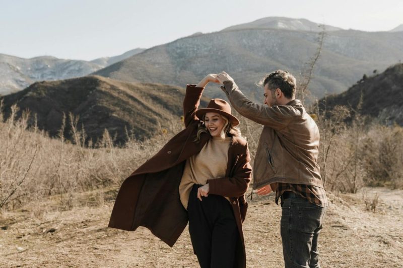 man and woman dancing on brown field