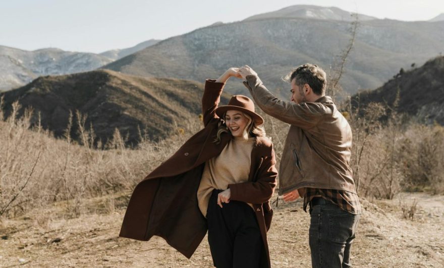 man and woman dancing on brown field