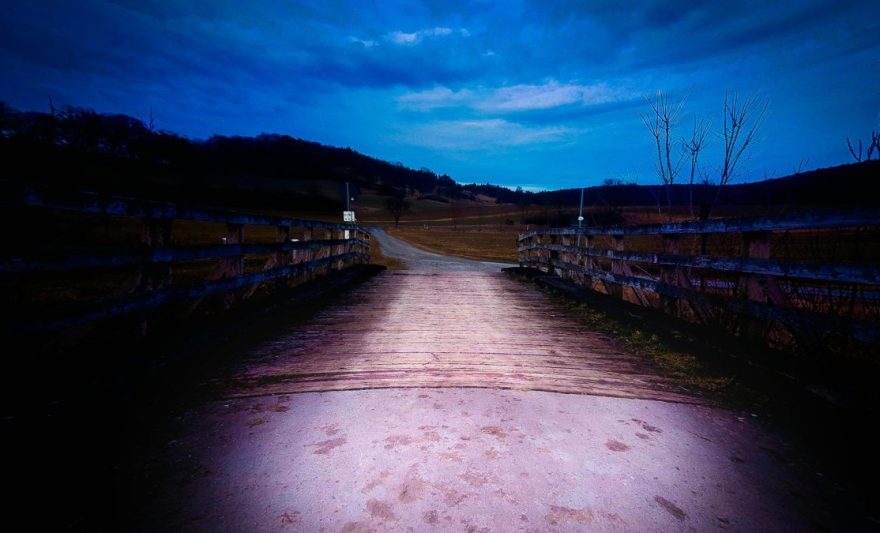 brown wooden bridge under blue cloudy skies