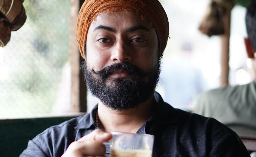 man with beard holding coffee cup