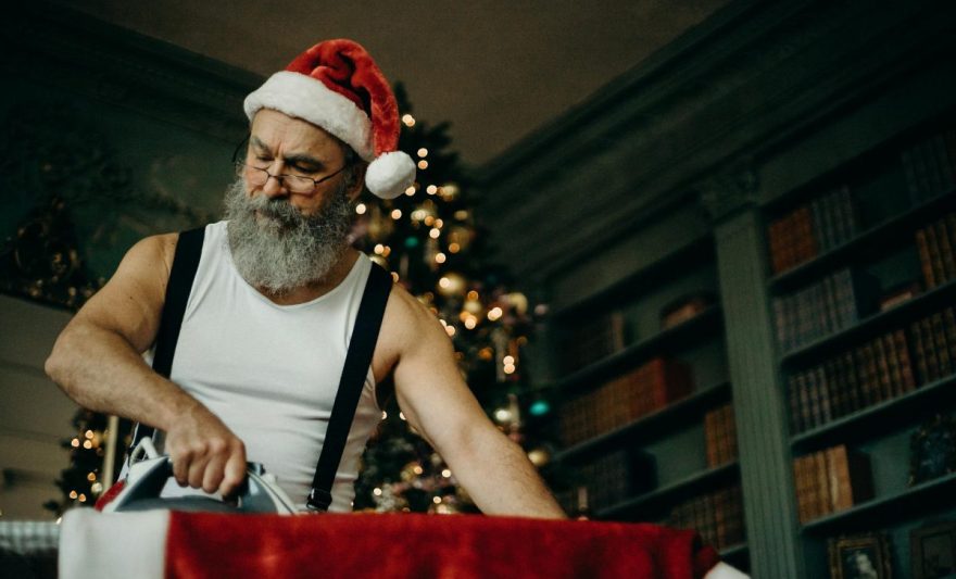 man in white tank top ironing red top