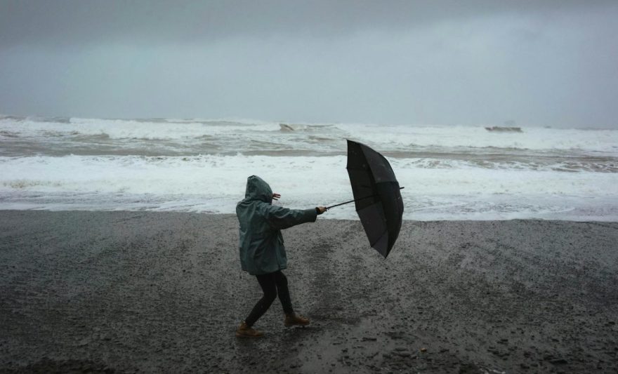 unrecognizable person with umbrella on beach