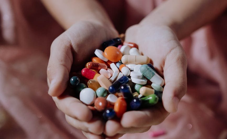 a handful of assorted medicines on a child s hands