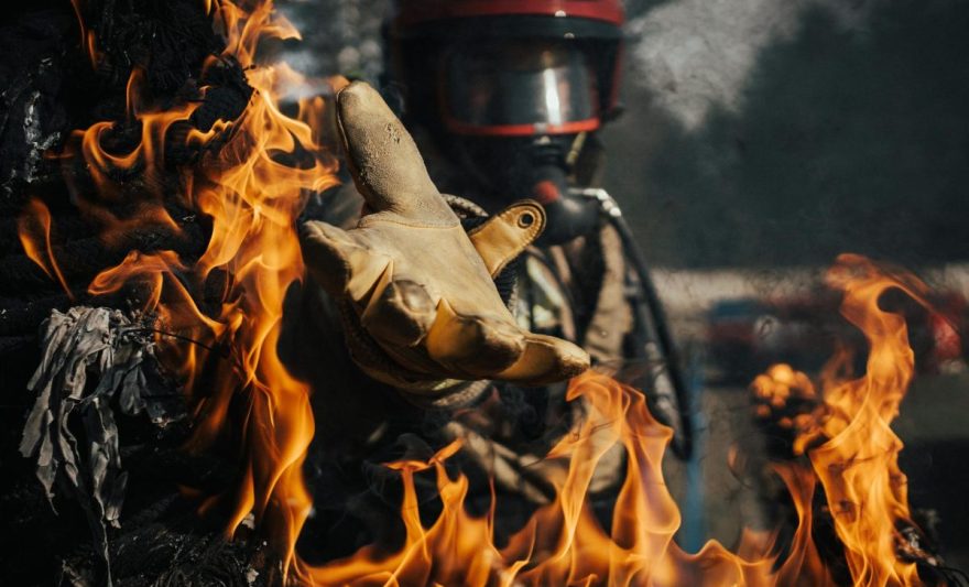 firefighter reaching in the fire