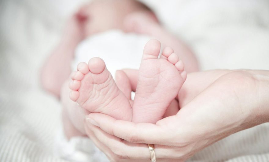 close up of hands holding baby feet