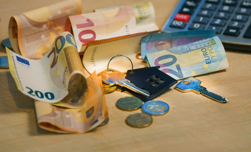 euro banknotes and keys on wooden surface