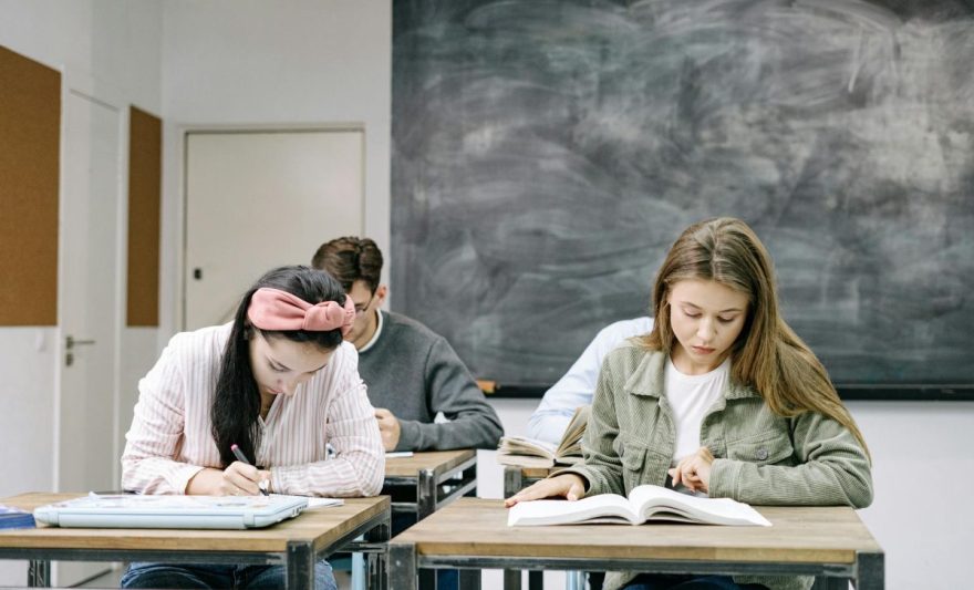 students sitting by the table in the classroom