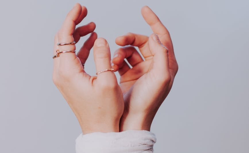 anonymous woman with tied hands against gray background