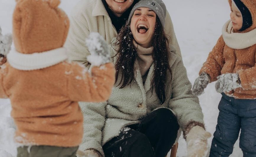 smiling family playing in snow