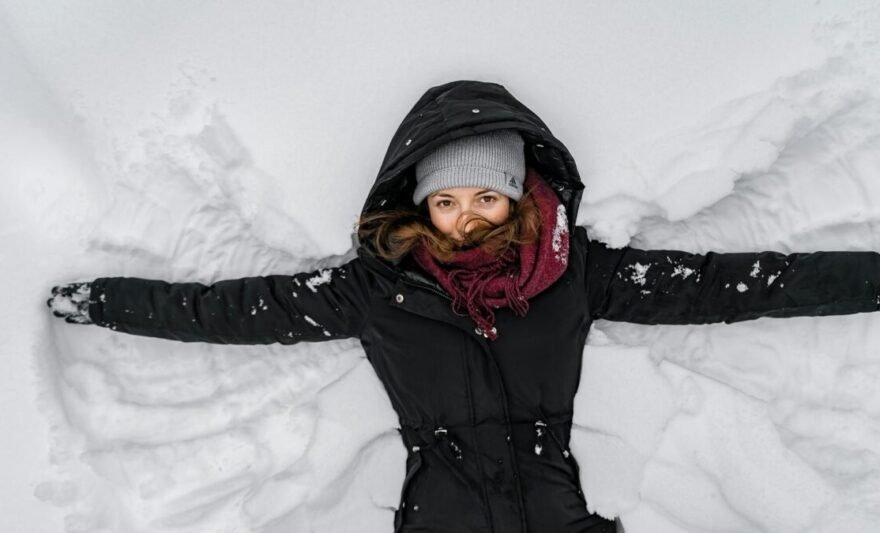woman in black jacket and gray knit cap on snow covered ground