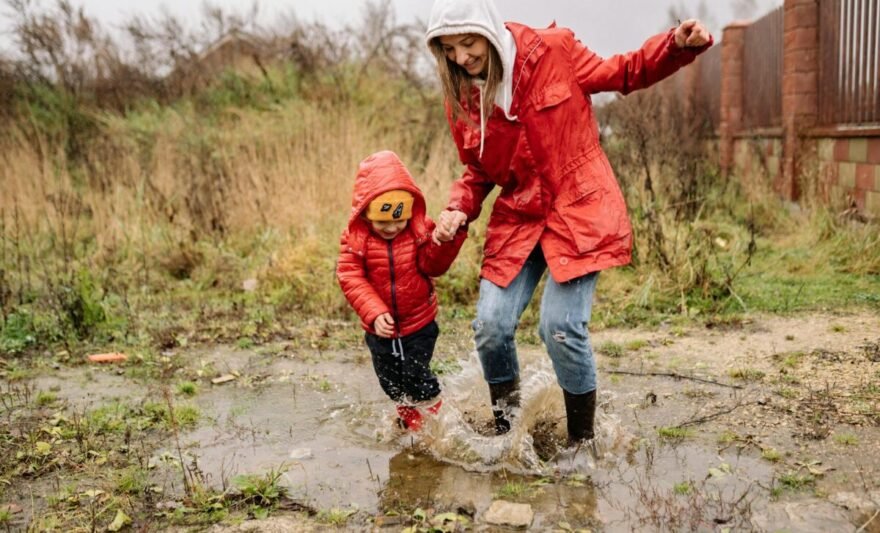 a woman playing on the rain with her child