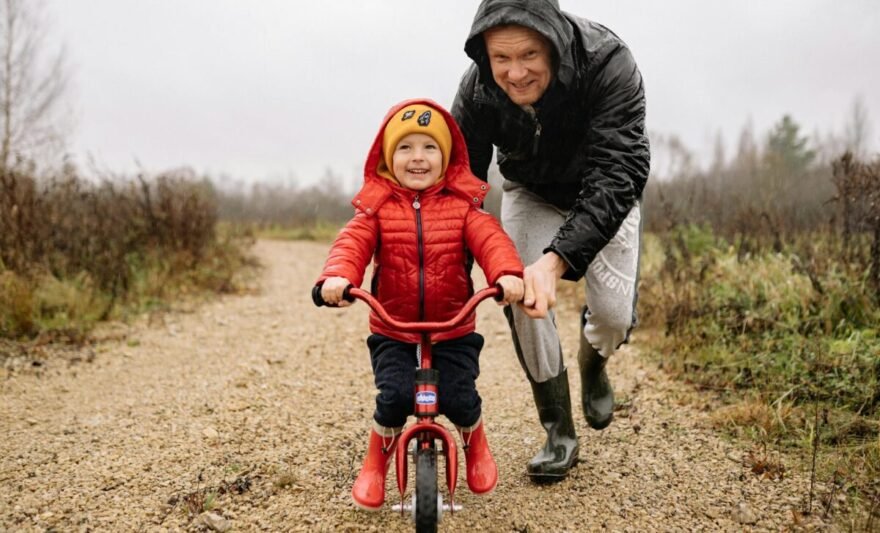 a father teaching his child how to ride a bike