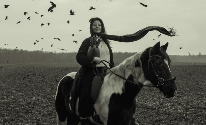 woman riding horse with birds in flight