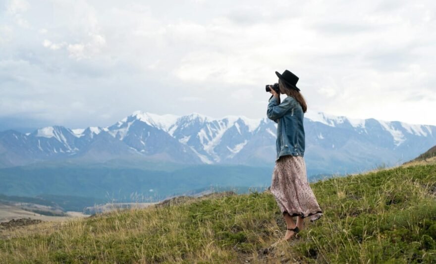 woman standing on grass field taking pictures