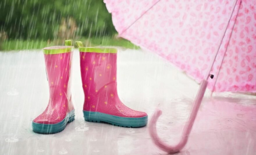 red and gray rain boots near pink umbrella