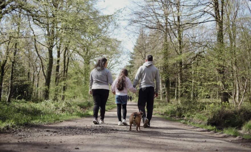 family walking with dog in forest