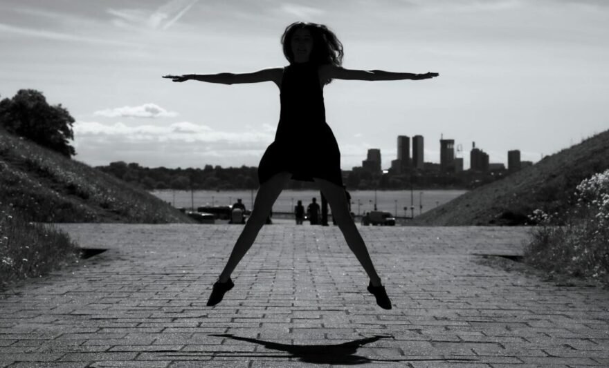 silhouette of woman jumping against tallinn skyline