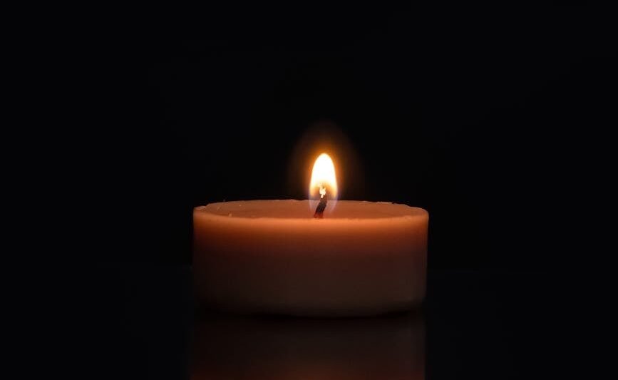close up photo of burning candle in dark background