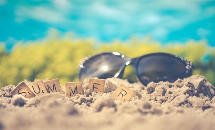 macro photography of black sunglasses on sand