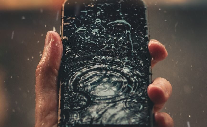 photo of person holding wet smartphone