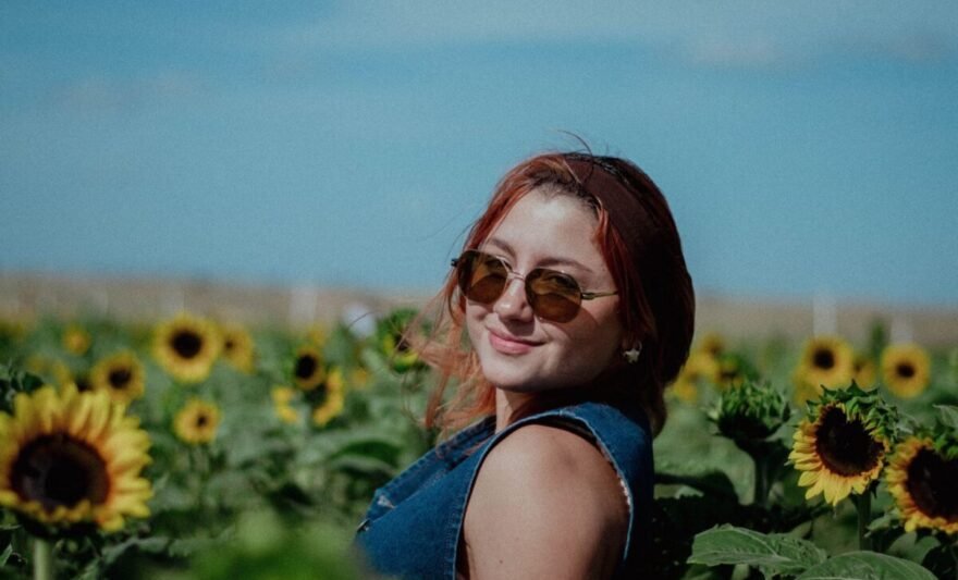 young woman in sunflower field on a sunny day