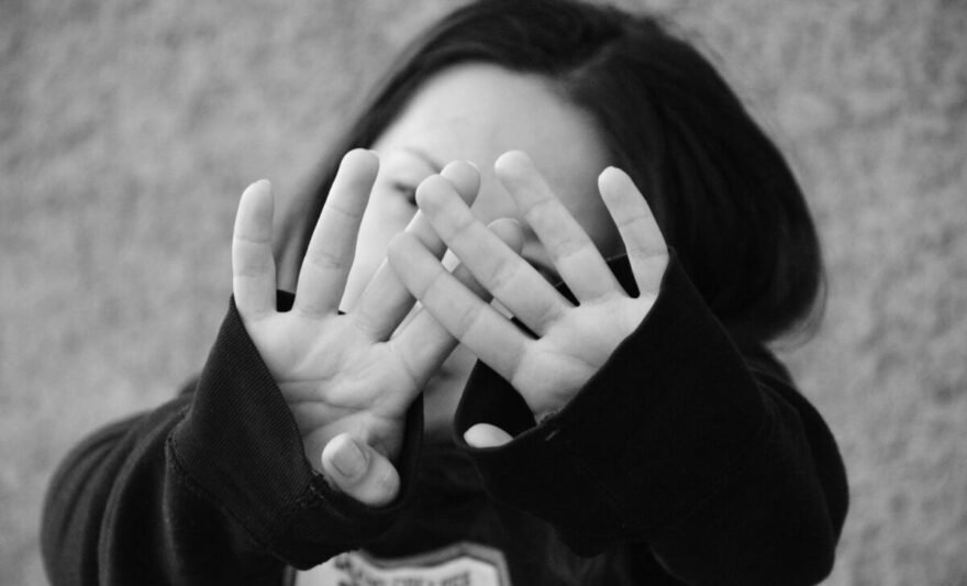 girl with hands raised in black and white