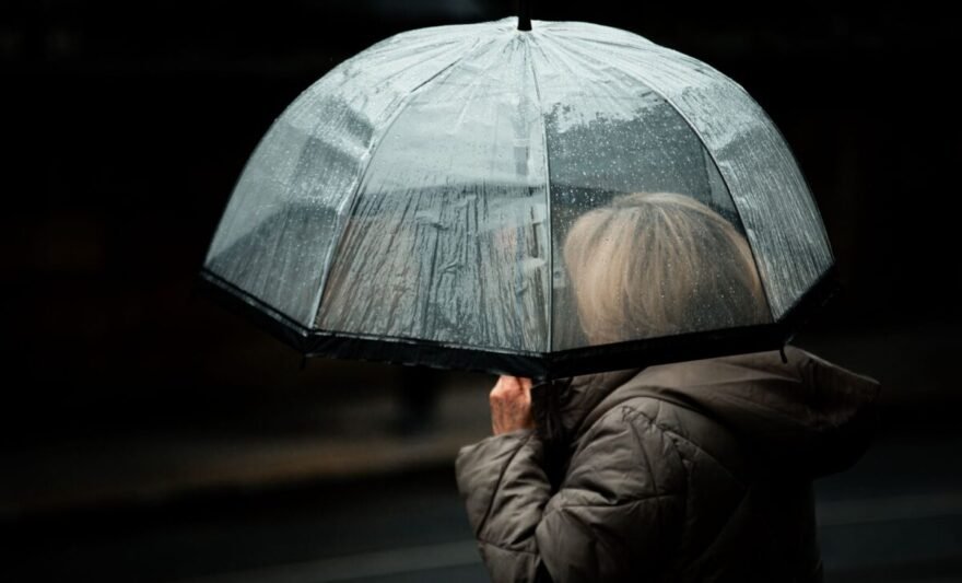 silhouette under a clear umbrella on a rainy day