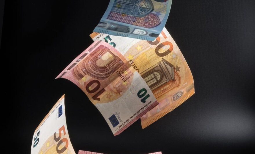 euro banknotes falling on desk