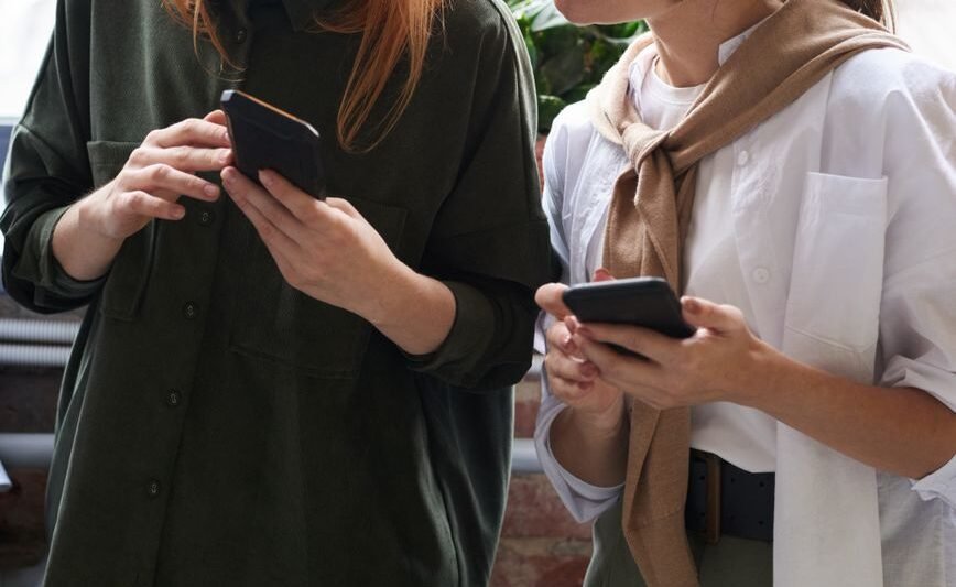 photo of women looking on their cellphones