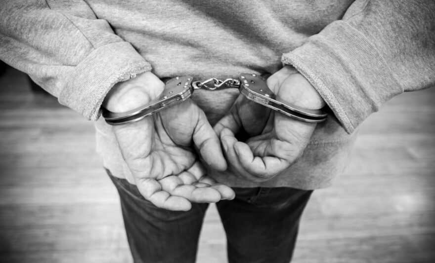 black and white image of person in handcuffs